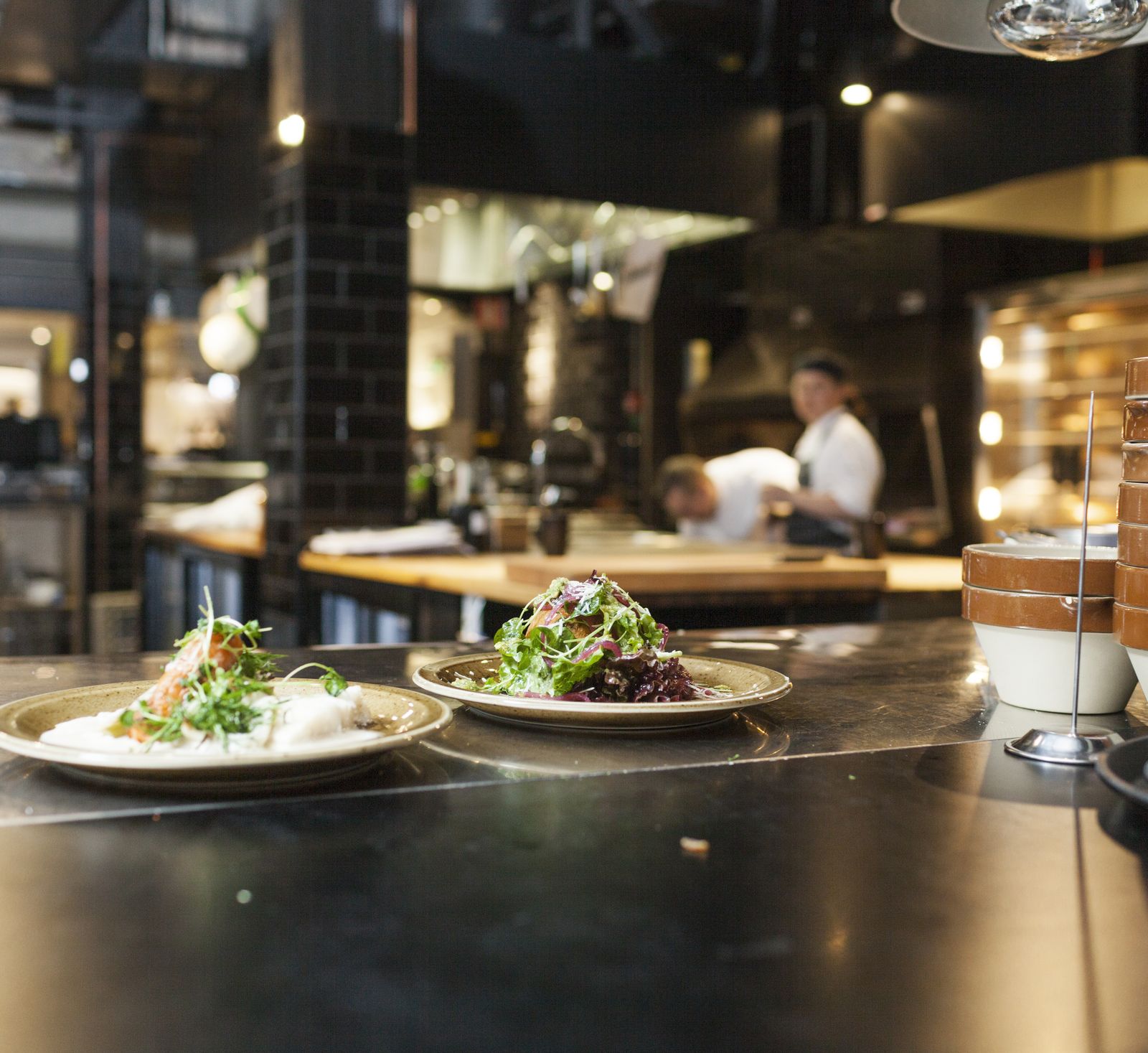 Plated dishes waiting on the counter of an open kitchen